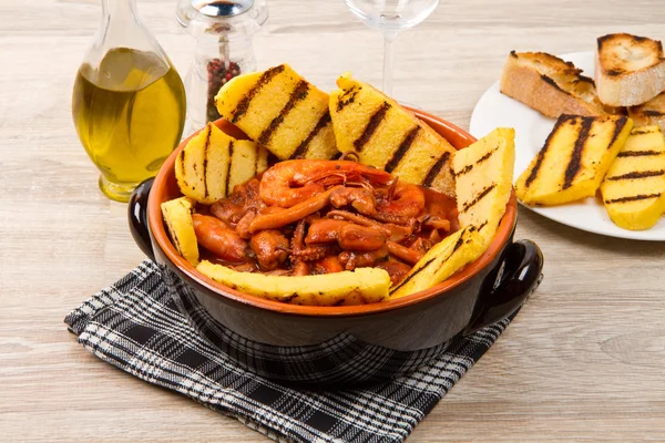 Fish soup with grilled polenta on crock pot — Stock Image Fish soup with grilled polenta on crock pot Stock Image