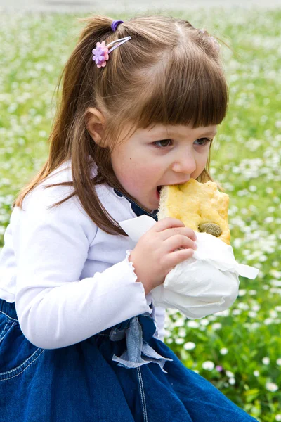 Petite belle fille manger un pain d'olives — Photo