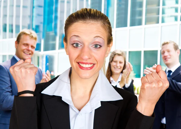 Business woman with arms up leading a successful team — Stock Photo, Image