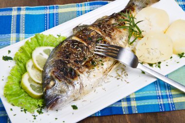 limon ve biberiye tabakta yaldızlı baş çipura ızgara ve