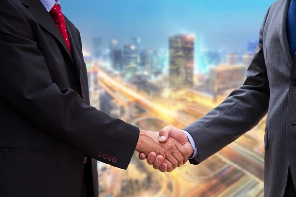 Handshake on background of buildings — Stock Photo, Image