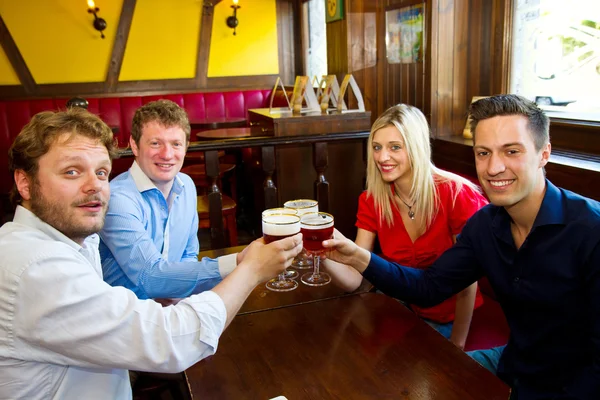 Die Leute stoßen mit einem leckeren hellen Bier an — Stockfoto