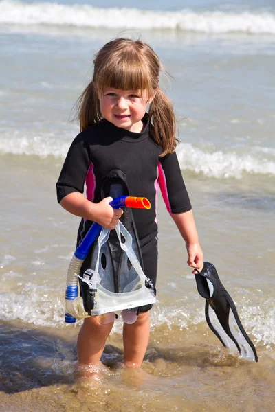 Happy girl on beach with colorful face masks and snorkels, sea i — Stock Photo, Image