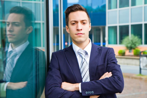 Улыбающийся молодой бизнесмен, стоящий у здания — стоковое фото