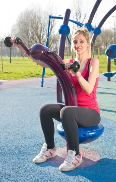 Retrato de mujer alegre en ropa de fitness haciendo ejercicio con equipar —  Fotos de Stock