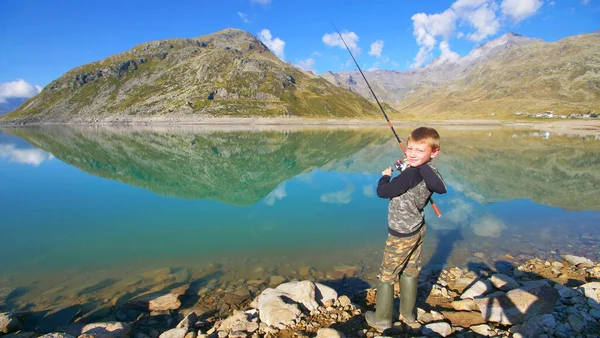 少年は美しい山の湖で釣りをしている — ストック写真