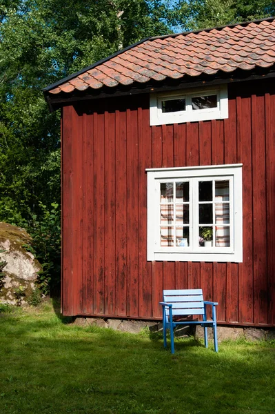 Sedia vuota alla luce del sole accanto a una casa in legno — Foto Stock