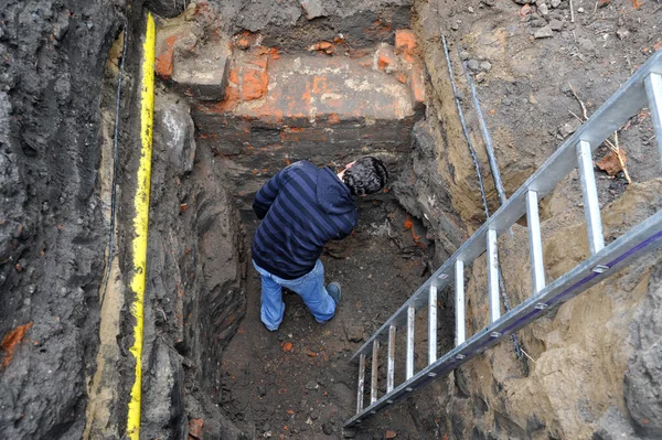 Arqueólogo examina uma parede medieval, parte de um edifício — Fotografia de Stock