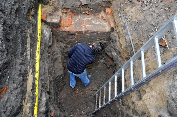 Archaeologist examines a medieval wall, part of a building — Stock Photo, Image