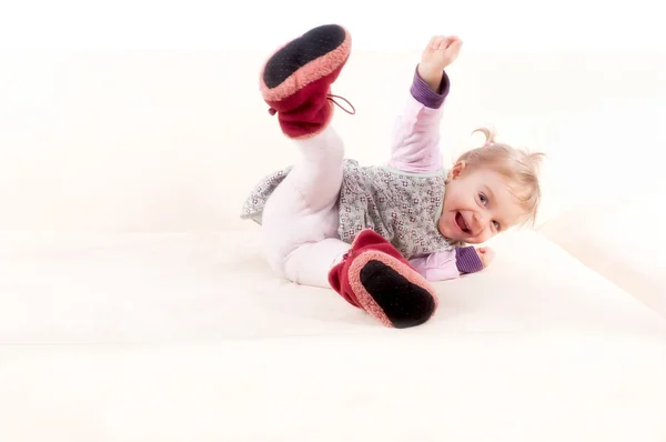 Mutlu bir kanepenin üzerinde oynarken sevimli küçük kız ve eğlenin. isolat — Stok fotoğraf