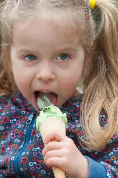 Χαριτωμένο κοριτσάκι τρώει παγωτό. Royalty Free Φωτογραφίες Αρχείου