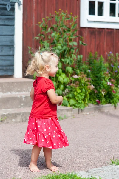 Söt liten flicka i röd sommarklänning — Stockfoto