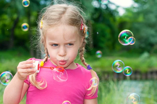 Petite fille soufflant des bulles de soa — Photo