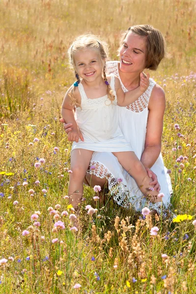 Mother and daughter dressed in white summer dresses enjoying a warm summer day — Stock Photo, Image