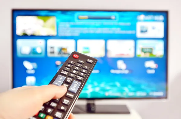 Smart TV und Handdrücken der Fernbedienung Stockfoto
