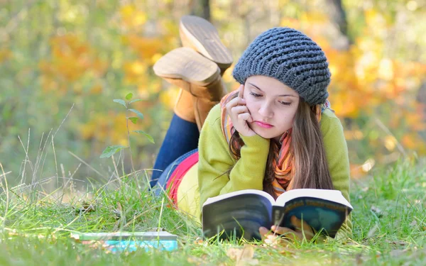 Mooi meisje lezen een boek outdoor — Stockfoto