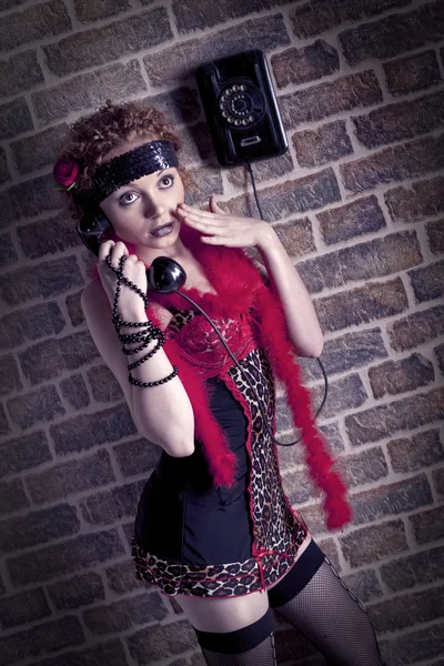 Bir tuğla duvar eski telefon olan kadın. — Stok fotoğraf