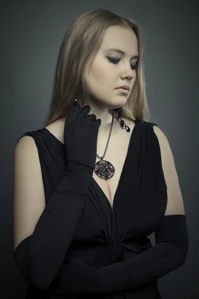 Mladá blonďatá žena v černých šatech studio shot. — Stock fotografie