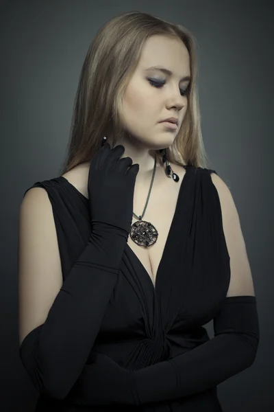 Young blond woman in black dress studio shot. — Stock Photo, Image