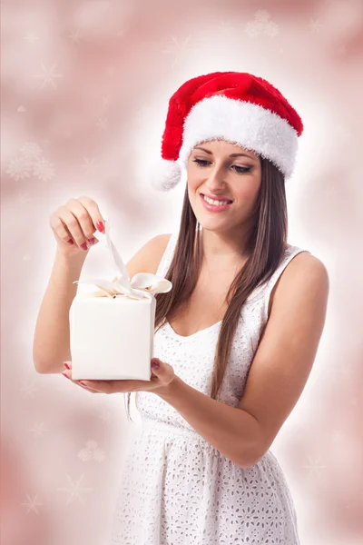 Attractive woman is opening a gift — Stock Photo, Image
