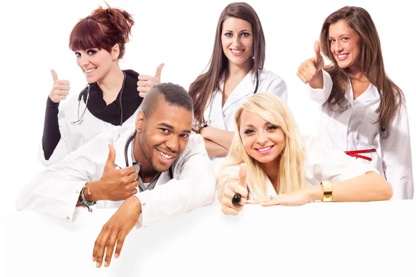 Jóvenes estudiantes de medicina sonriendo haciendo gesto positivo en el pulgar — Foto de Stock