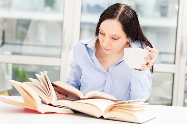 Studente donna che impara a casa con diversi libri — Foto Stock