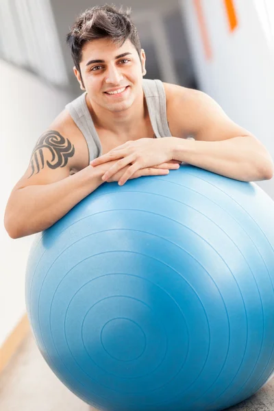 Sorrindo homem com bola de ginástica azul — Fotografia de Stock