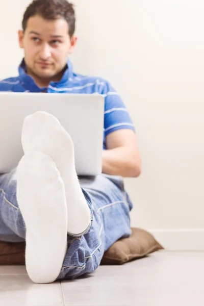 Junger Mann sitzt mit Notizbuch auf dem Boden — Stockfoto