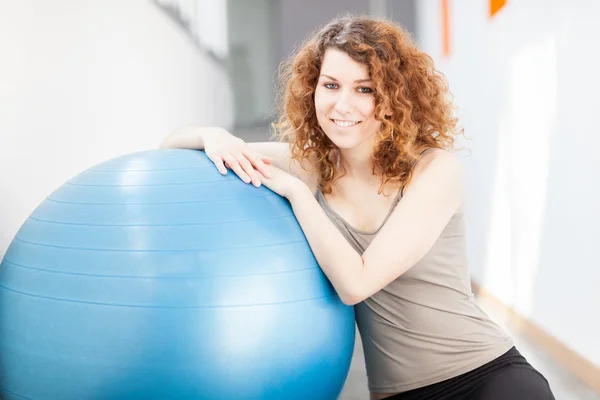 Jovem fazendo exercício com uma bola de ginástica — Fotografia de Stock