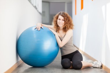 genç kadın bir jimnastik topu ile egzersiz yaparak