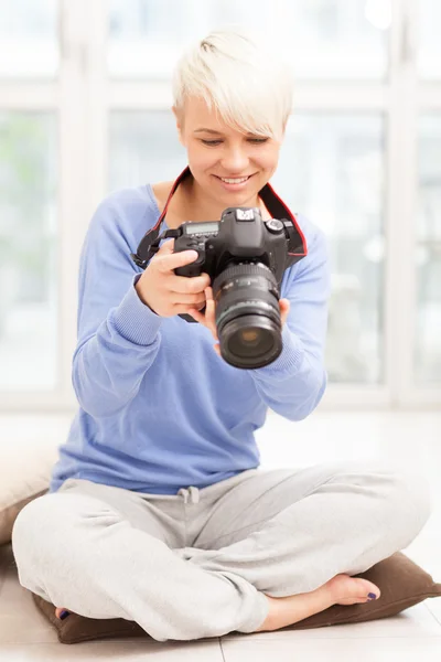 Női fotós DSLR otthon ül a földön — Stock Fotó