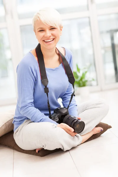 Kobieta fotograf z dslr w domu siedzi na podłodze — Zdjęcie stockowe