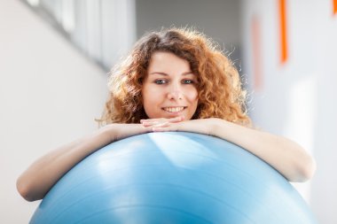 genç kadın bir jimnastik topu ile egzersiz yaparak