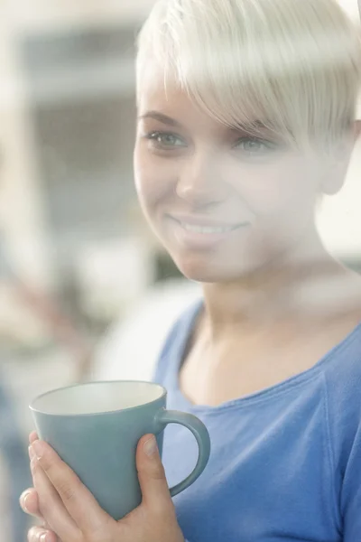 Atractiva mujer disfrutando de su café detrás de una ventana — Foto de Stock