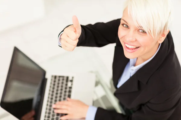 Businesswoman making positive thumb gesture — Stock Photo, Image