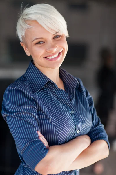 Femme d'affaires portant une chemise et souriant devant un dos sombre — Photo