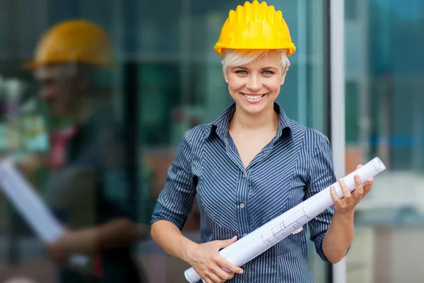 Portret van vrouwelijke constructor met blauwdrukken — Stockfoto