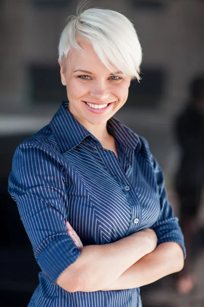 Affärskvinna klädd i skjorta och leende framför en mörk backg — Stockfoto