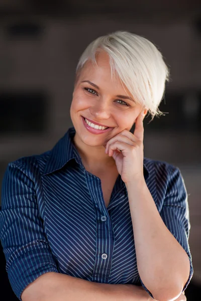 Mulher de negócios vestindo camisa e sorrindo na frente de um backg escuro — Fotografia de Stock