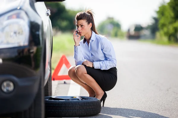 Conceptual photo of woman with a flat tire Royalty Free Stock Photos
