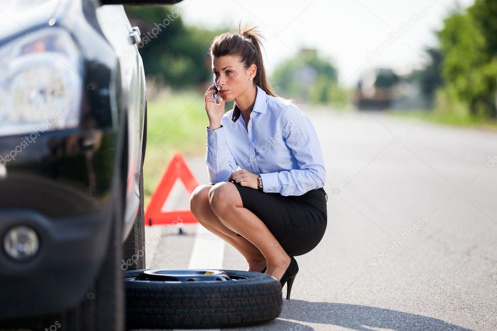 Conceptual photo of woman with a flat tire Stock Photo by