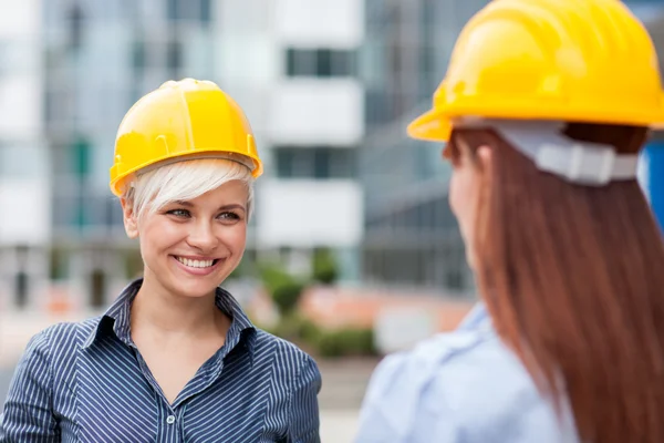 Lächelnde Bauarbeiterinnen treffen aufeinander — Stockfoto