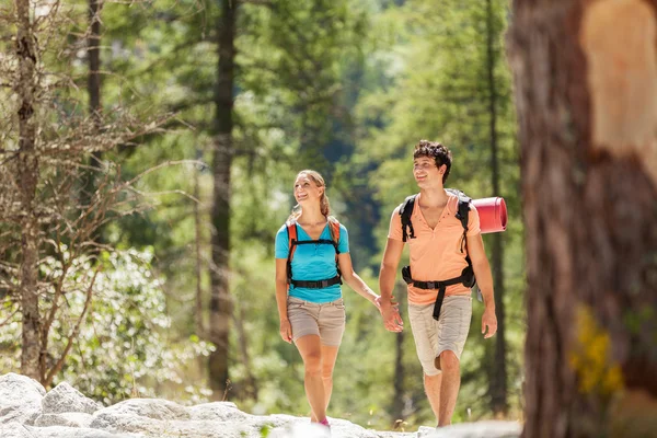 Couple is walking through the woods while smiling — Stock Photo, Image