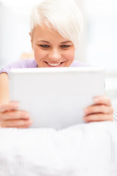 Lächelnde Frau im Bett mit Tablet-PC — Stockfoto