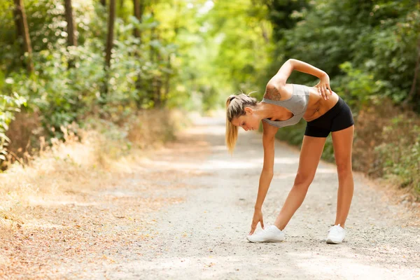 Sexy donna bionda sta facendo esercizi di stretching — Foto Stock
