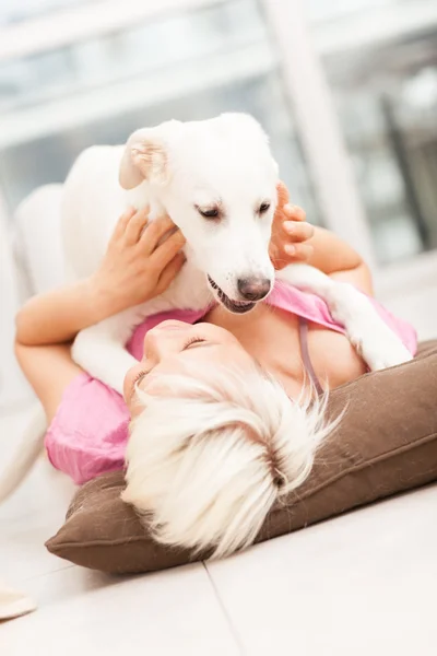 Blonde woman is playing with her dog — Stock Photo, Image