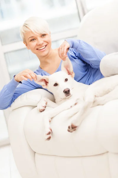 Blonde vrouw speelt met haar hond — Stockfoto