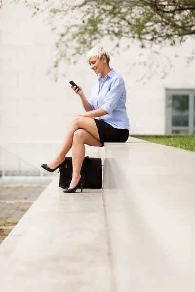 Attraente donna d'affari che controlla il suo telefono — Foto Stock