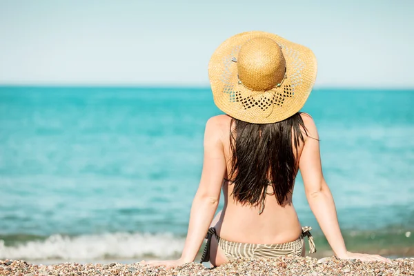 Mujer sentada en la orilla del mar mirando el agua —  Fotos de Stock