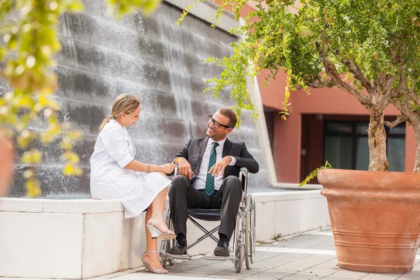 Женщина-доктор разговаривает с бизнесменом на инвалидной коляске — стоковое фото